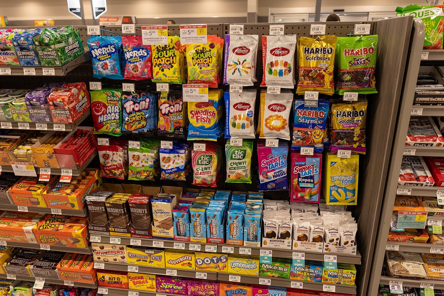 Candy products of many different brands displayed on a supermarket shelf