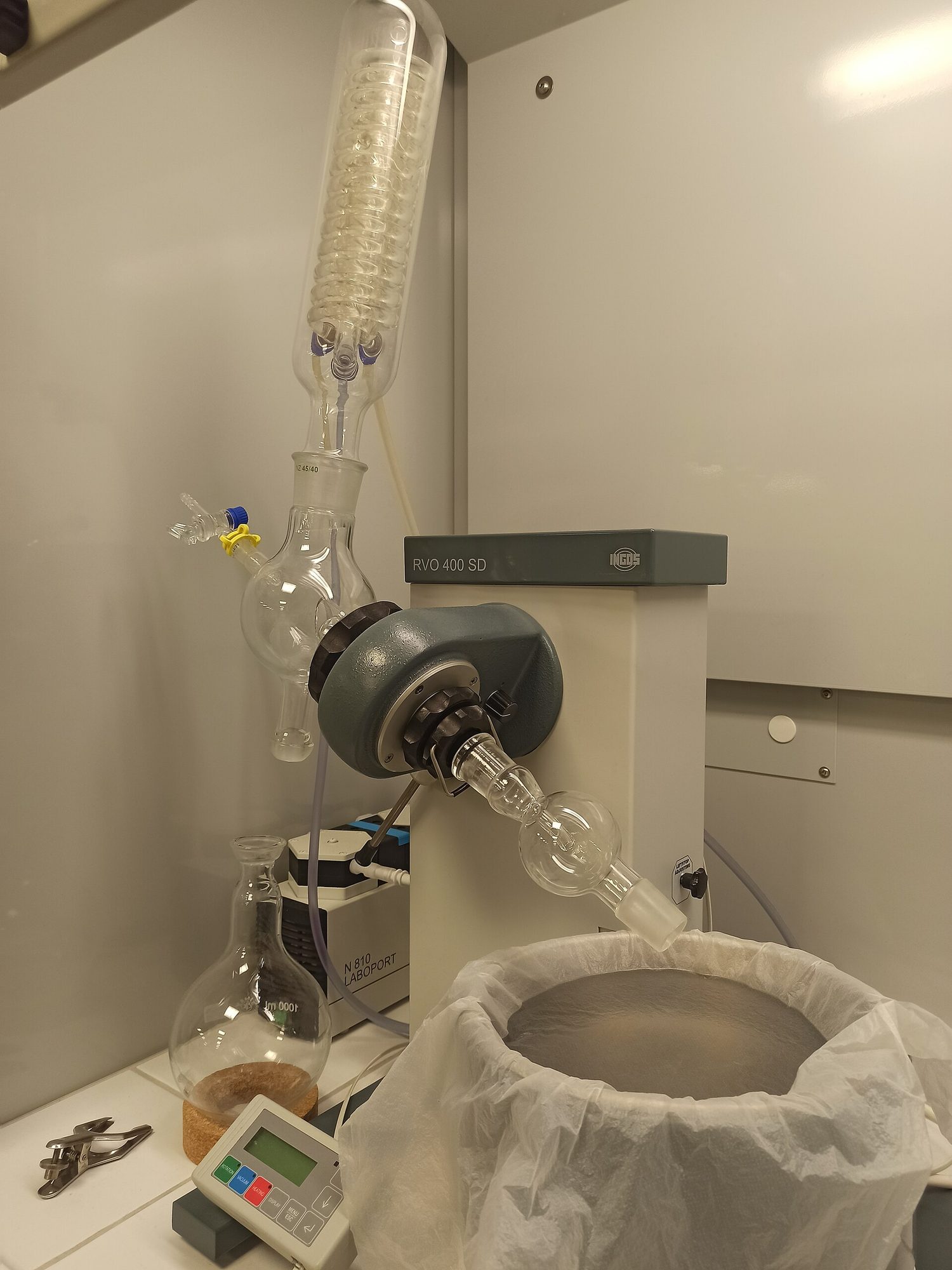 A rotary evaporator: a round flask of solution turning in a warm water bath, with the solvent vapour condensing into a separate receiving flask