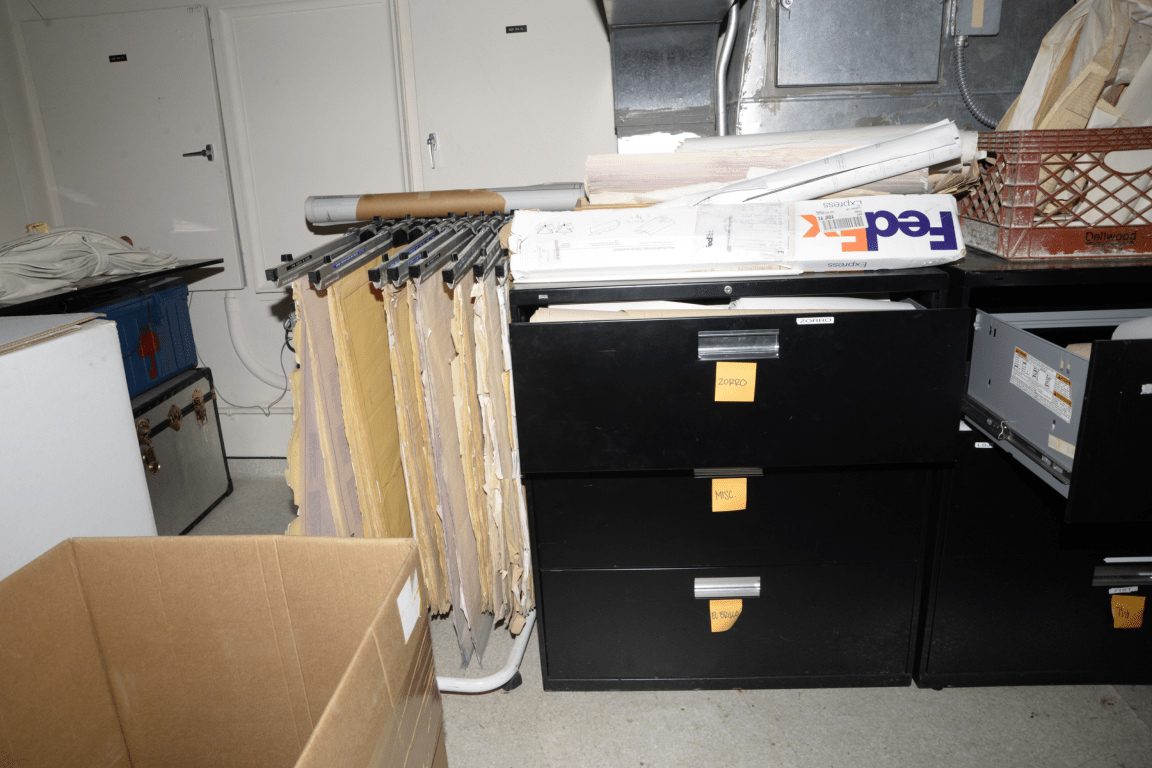 A hand searching a card-index filing cabinet