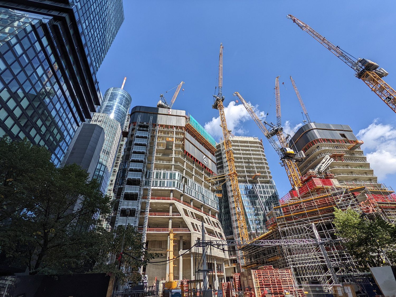 Several skyscrapers under construction with tower cranes