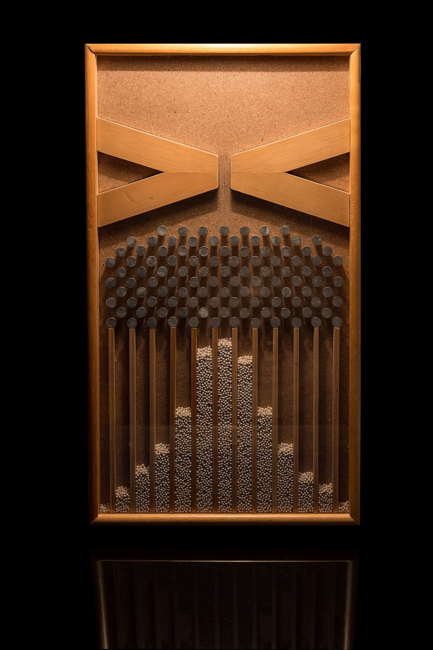 A Galton board with balls piled into a bell shape
