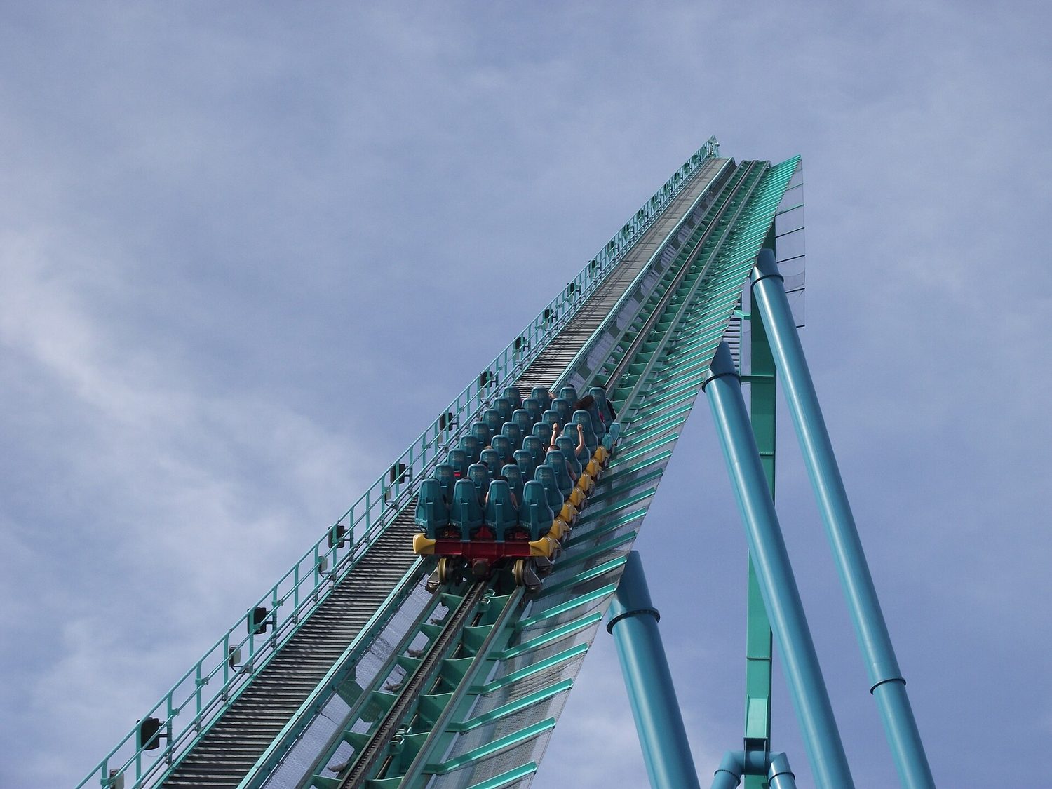 A roller-coaster train being hauled up the steep lift hill by its chain