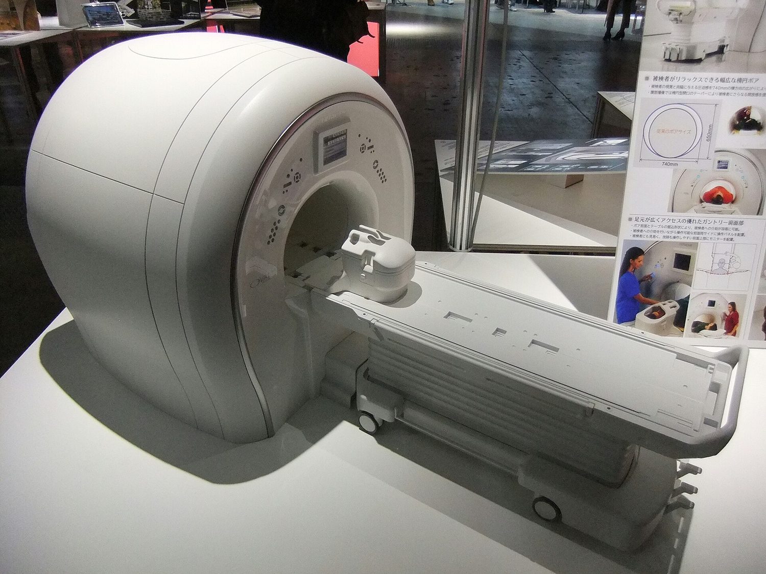 An MRI scanner: a large white ring-shaped magnet with a patient table sliding into its bore