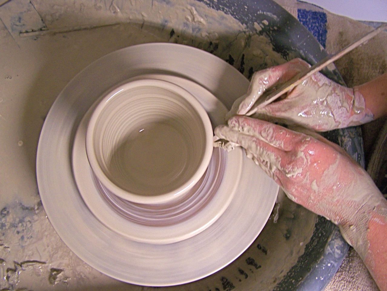 A potter shaping a vessel: volumes of revolution rotate a plane region about an axis