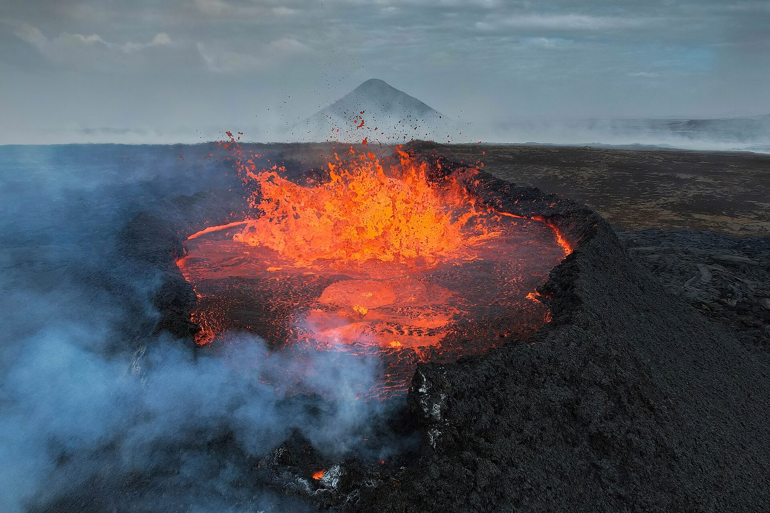 明亮橙色的熔岩从冰岛一个黑暗的火山口喷涌而出