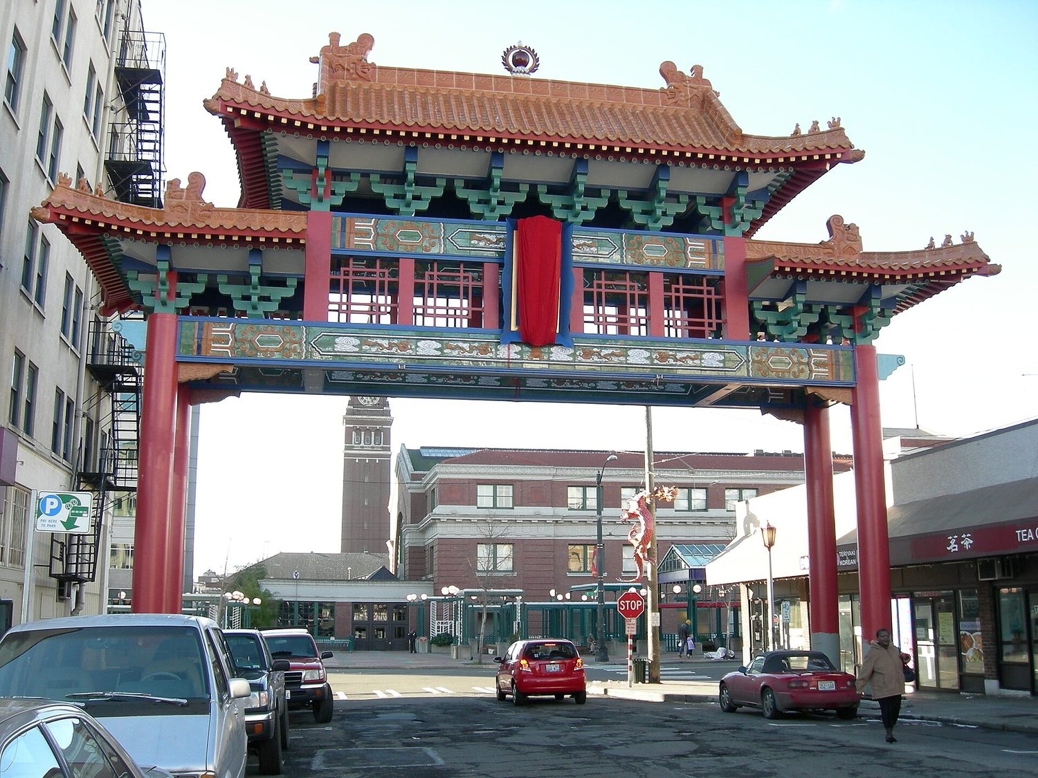 一座大而华丽的中国传统牌楼,绿色琉璃瓦屋顶横跨街道,标志着西雅图唐人街的入口