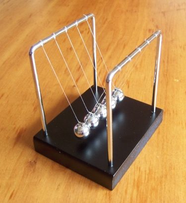 A Newton's cradle: five steel balls hanging in a row