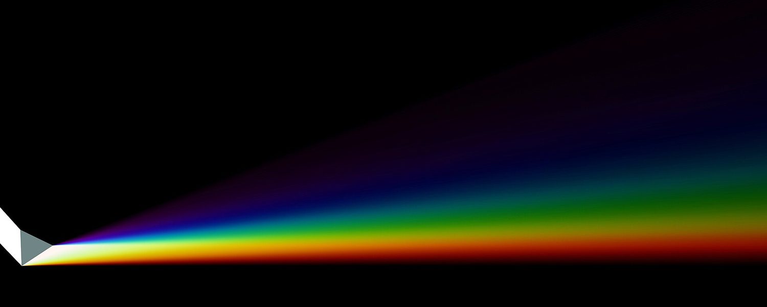 White light splitting into a spectrum through a glass prism