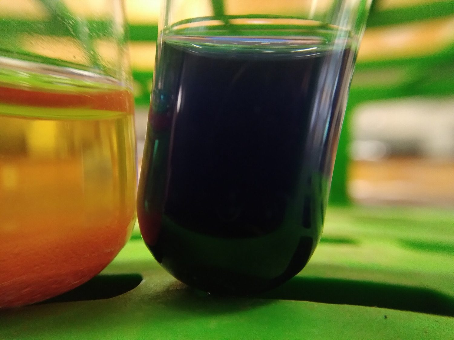 A test tube after Benedict's test: the liquid has gone orange with a brick-red precipitate settling at the bottom